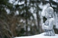 Buddha statue with snowfall and snow in winter