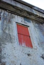 A stone building with a red door on an old deserted property. Architecture details of the exterior of a grey industrial Royalty Free Stock Photo