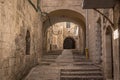 The stone-built alley with the arch and stairs deep in Jerusalem Old Town in Jerusalem. Royalty Free Stock Photo