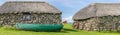 Stone built cottages with thatched roofs. fishing boats moored outside a home Royalty Free Stock Photo