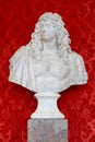 stone bust with a red background at the museum of versailles.