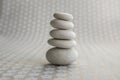 Stone cairn on gray background with flowers stars, five stones tower, simple poise stones, simplicity harmony and zen balance Royalty Free Stock Photo