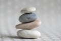 Stone cairn on striped grey white background, four stones tower, simple poise stones, simplicity harmony and balance