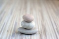 Stone cairn on striped grey white background, three stones tower, simple poise stones, simplicity harmony and balance, rock zen