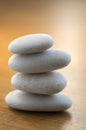 Stone cairn tower, poise stones, rock zen sculpture, light white pebbles on wooden background Royalty Free Stock Photo