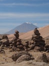 Stone cairns manmade balancing tower stacked rocks along road from Colca Canyon to Arequipa with Misti volcano Peru