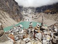 Stone cairns overlooking a turquoise glacier lake surrounded by rugged mountains Royalty Free Stock Photo