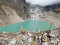 Stone cairns overlooking a turquoise glacier lake surrounded by rugged mountains Royalty Free Stock Photo