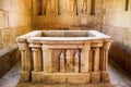 stone carved baptismal font with water