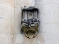 A stone carved head with a tongue out on the wall of a neo-Gothic chapel in Quinta da Regaleira in Sintra