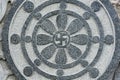 Stone carved radial design with Buddhist swastika symbol at the centre