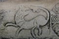 Stone carving of tail chasing dog