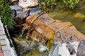 Stone cascading waterfall in an artificial pond. Royalty Free Stock Photo