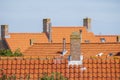 Stone chimneys on the roofs with orange roof tiles Royalty Free Stock Photo