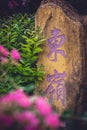 Stone with chinese characters painted in purple colour