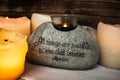 Stone with christian scripture with light candle Royalty Free Stock Photo