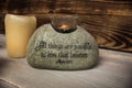 Stone with christian scripture with light candle Royalty Free Stock Photo