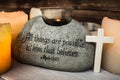 Stone with christian scripture with light candle cross Royalty Free Stock Photo