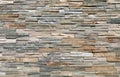Stone cladding wall made by elongated bricks of natural multicolor rocks. Panels for exterior Royalty Free Stock Photo