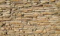 Stone cladding wall made of striped stacked slabs of natural brown rocks. Royalty Free Stock Photo