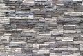 Stone cladding wall made of striped stacked slabs of natural rocks. Colors are dark gray and white