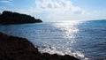 Stone coast on background of sea horizon in Sunny weather. Concept. Empty rocky coast with buoys and sun glare on water Royalty Free Stock Photo