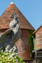 Stone cockerel against a Kent Oast house. Royalty Free Stock Photo