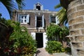 Stone colonial house in caribbean with blue window shutters Royalty Free Stock Photo