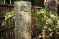 A stone column in a corner of Japanese garden in Kyoto with Japanese letters on it