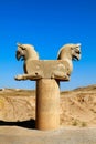 Stone column sculpture of a Griffin in Persepolis against a blue clear sky.