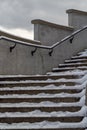 Stone concrete snow-covered stairs with footprints in the city in winter. Stairs with ice and snow Royalty Free Stock Photo