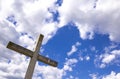 Stone cross behind clouds against blue sky