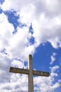 Stone cross behind clouds against blue sky