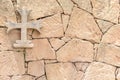 Stone cross hanging on a stone wall, background Royalty Free Stock Photo