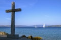 Stone cross installed near the sea. Christian symbolism. In the background is the sea. Royalty Free Stock Photo