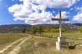 Stone cross on the mountain above clouds against blue sky Royalty Free Stock Photo