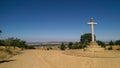 Stone cross at the side of a dirt road. Royalty Free Stock Photo