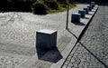 Stone cubes barriers as protection of a nice lawn cube cubes on a paved sidewalk platform of a tram protected from the entry of ca Royalty Free Stock Photo