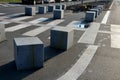 Stone cubes barriers as protection of a nice lawn cube cubes on a paved sidewalk platform of a tram protected from the entry of ca Royalty Free Stock Photo