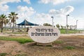 A stone with description Sir Charles Clore park and palm trees at the Tel Aviv beach in Isael