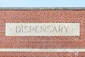 Stone dispensary sign on a brick building