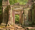 Stone doorway guarded by two warrior statues at Ta Prohm temple ruins, located in the Angkor Wat complex near Siem Reap, Cambodia. Royalty Free Stock Photo