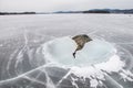 A stone is dramatically breaking the ice, literally