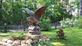 Stone eagle on a pedestal in the center of a green lawn in the Latvian resort city of Jurmala. August 2019