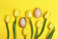 Stone Easter eggs and beautiful yellow tulips. Minimal style composition with Easter concept. Spring blossom flowers
