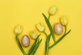Stone Easter eggs and bouquet of beautiful yellow tulips. Minimal style composition with Easter design concept