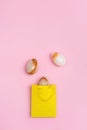 Stone Easter eggs in yellow paper bag. Holiday minimal style composition. Easter concept.