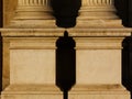 Stone exterior column base in frontal view. classical architecture. copy space. dark shadows. grooved columns.