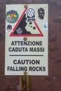 stone fall warning sign on a foggy day on the pedestrian path to the top of the mount vesuvio volcano. Naples, Italy.