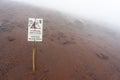 stone fall warning sign on a foggy day on the pedestrian path to the top of the mount vesuvio volcano.  Naples, Italy. Royalty Free Stock Photo